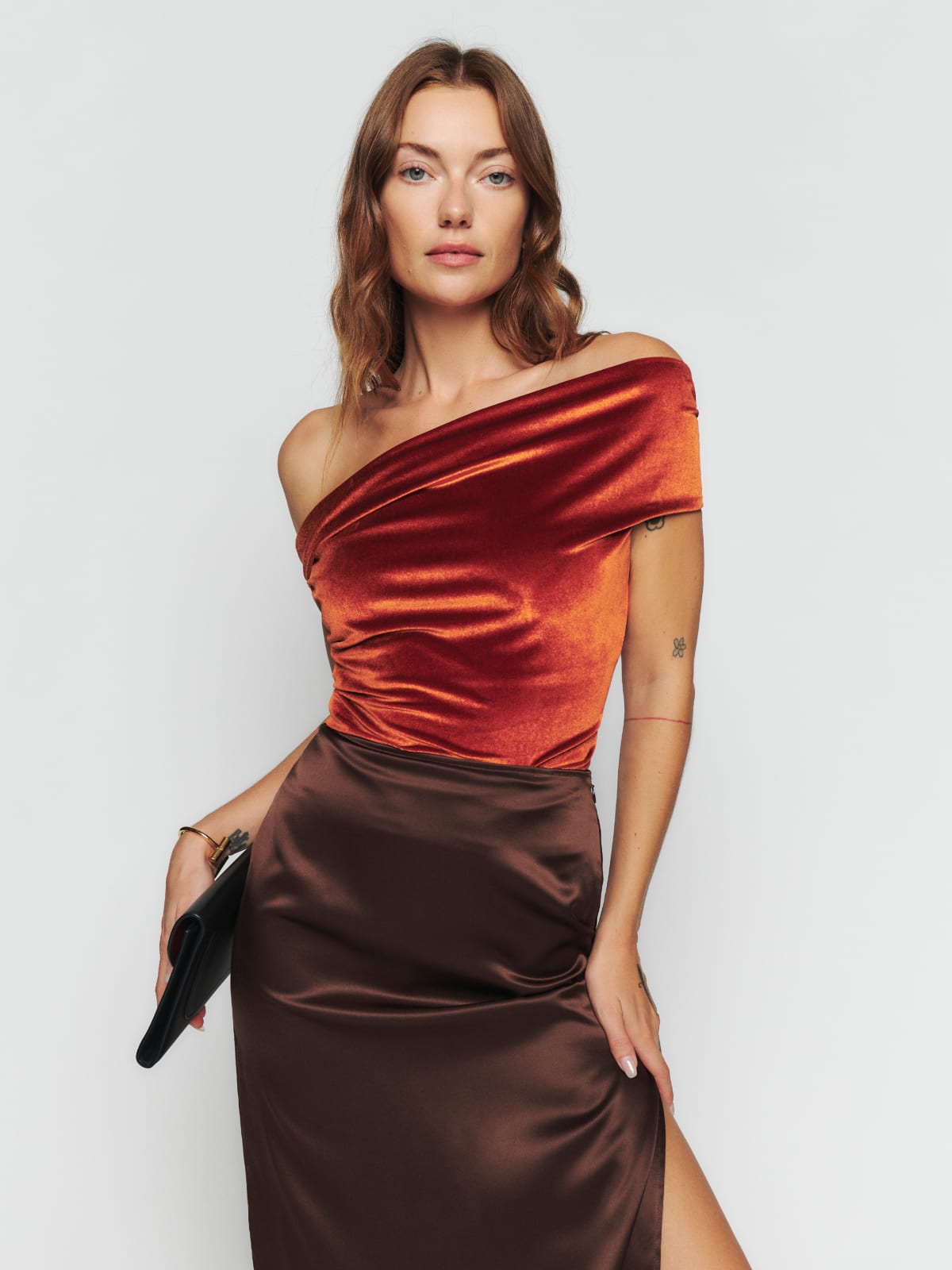 Reformation burnt orange velvet off-shoulder top with asymmetric one shoulder look. Fitted bodice. It has  Ruching at neckline and on the bodice. 