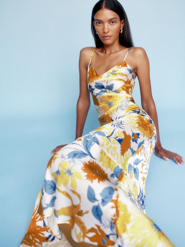 Reformation The Parma ankle-length slip dress is slim fitting throughout. It has adjustable straps and gives you some shape without sacrificing comfort. It has a beautiful white based floral in multicoloured blues, yellows and rust tones. 