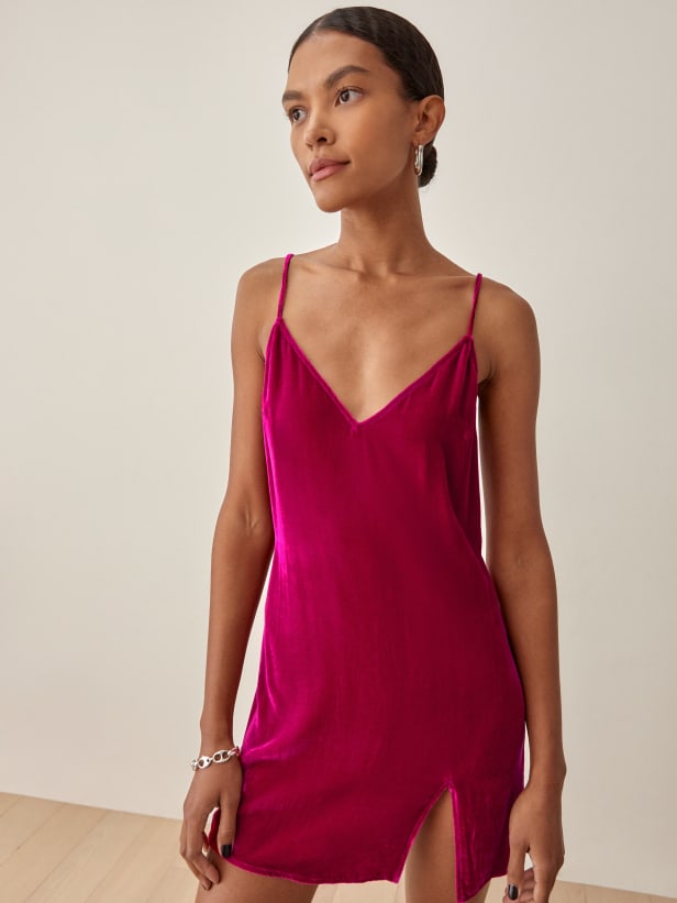 Reformation Lyza magenta pink velvet mini dress has a relaxed fit throughout with thin adjustable straps, a v neck and a small slit at the thigh. 