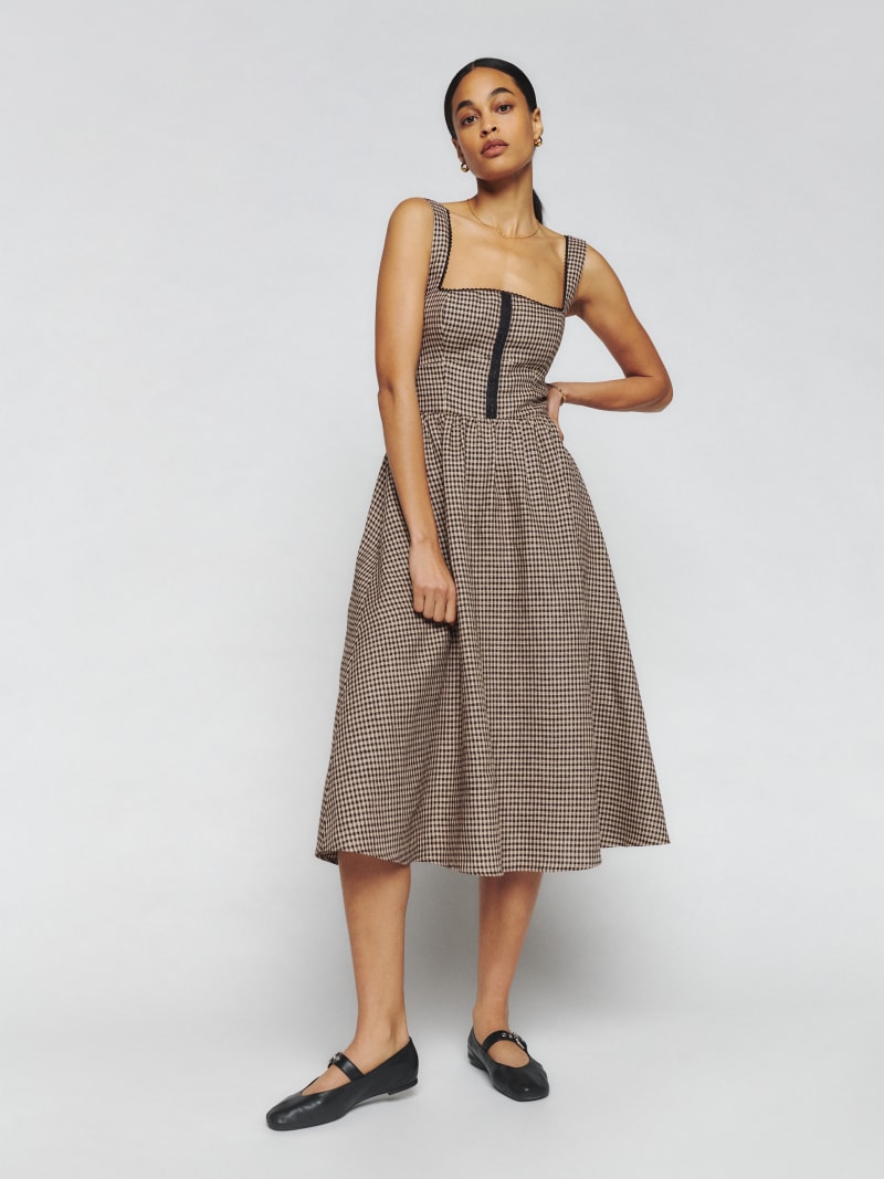 Reformation Tagliatelle gingham Linen Dress has back smocking, non-adjustable straps, and a curve neckline. A-line midi skirt, center back zipper, corset detailed bodice, fitted in waist, lace trim. 