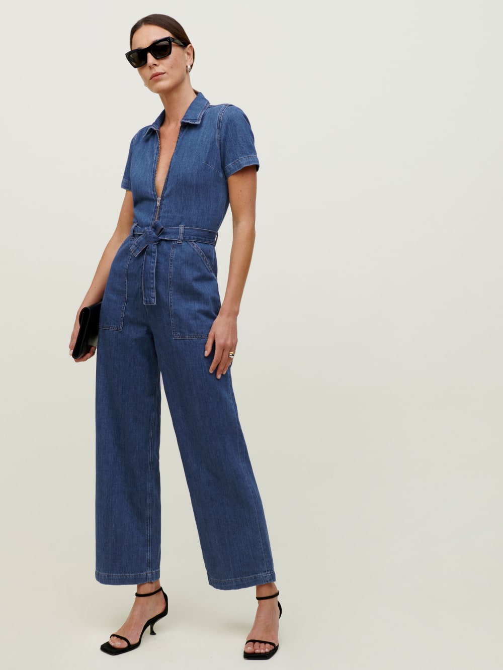 Denim full length, short sleeve jumpsuit with a deep v neckline. It features a functional, center front zipper and a self tie around the waist so you can adjust to your liking.
