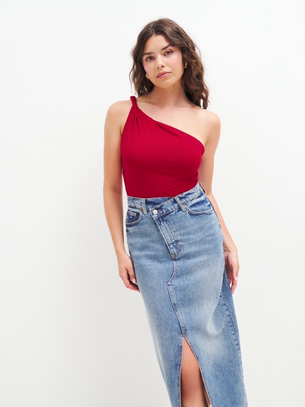 Tap into the red trend this season with Reformation's Sianna knit top in red. It has a one-shoulder neckline with twisted strap detail and a form-fitting silhouette. 