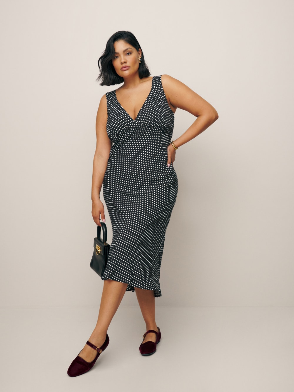 Reformation Beauden polka dot midi dress in navy and white has Adjustable wide straps, v-neck neckline and a bias cut. 