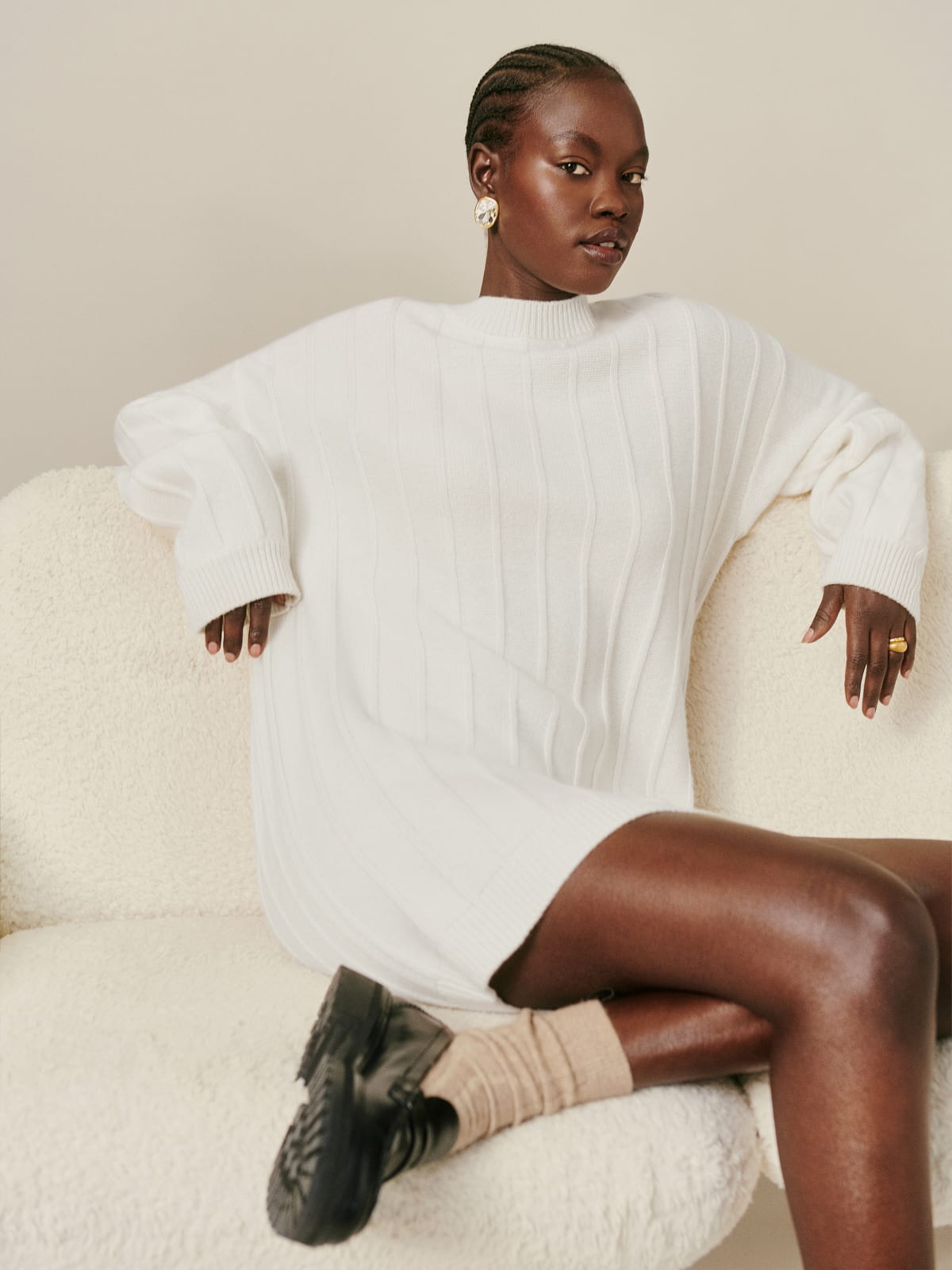 The Reformation Harriet regenerative wool mini dress is a long sleeve, mini, sweater dress in a relaxed fit in cream and ribbed detailing throughout and a round neck. 