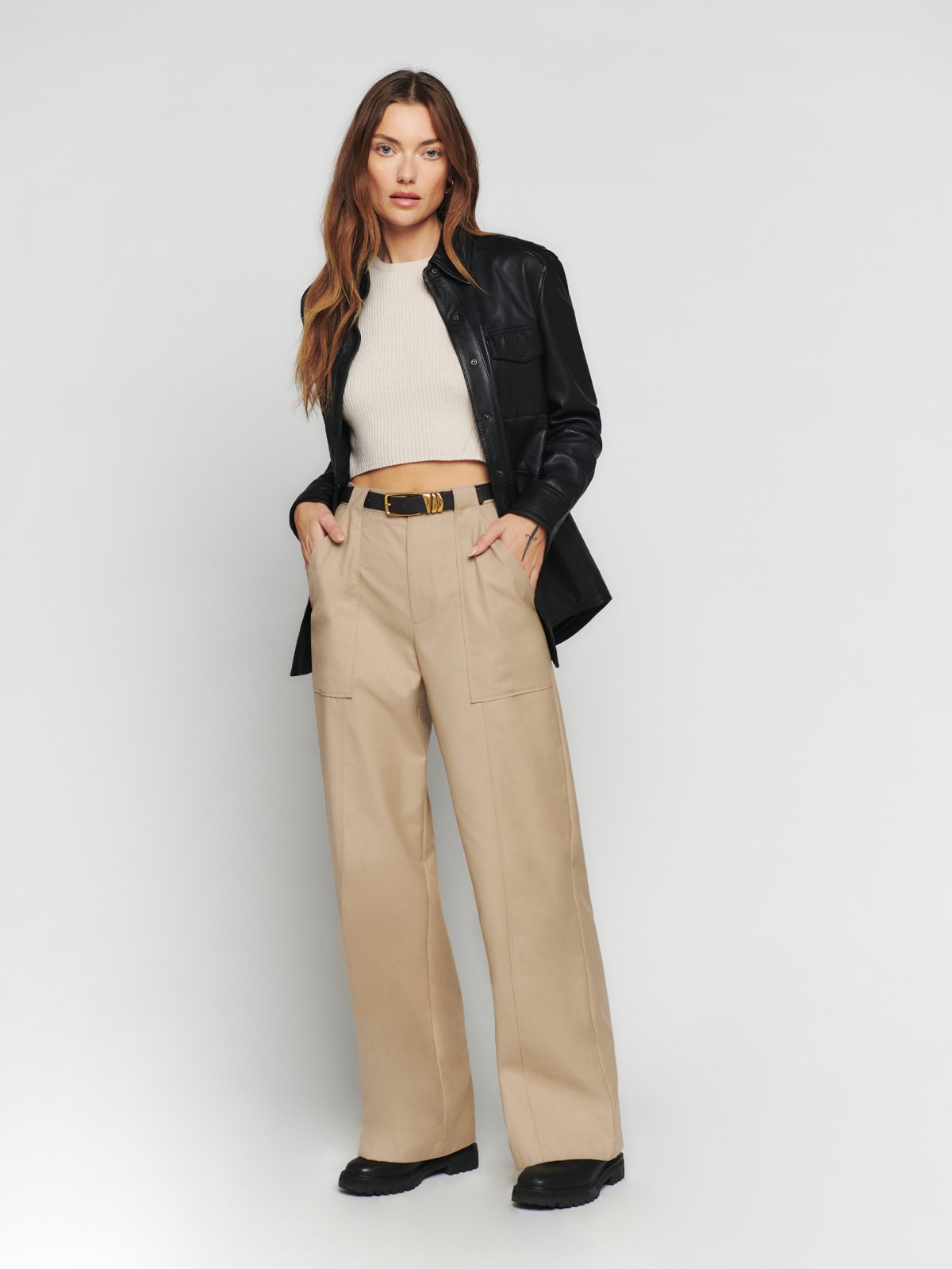 The Reformation Noah pant is a high-rise pant with slightly flared, wide legs and princess seams. It features belt loops, functional front pockets, and back pocket details.
