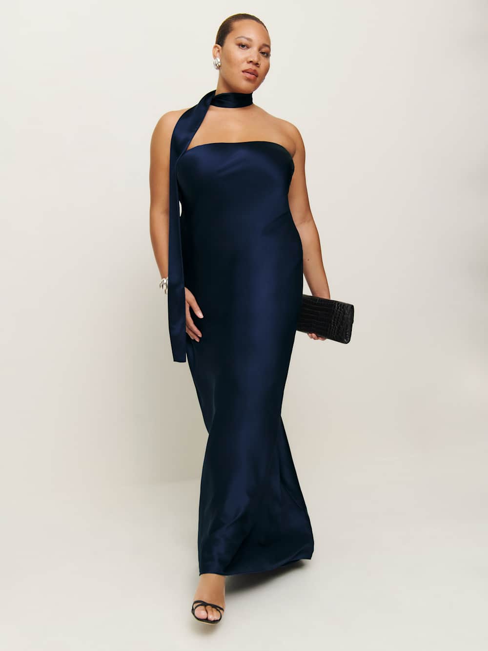 A plus-size, strapless, navy slip dress with a neck scarf
