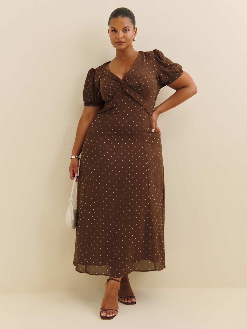 A plus-size, puff-sleeve, chocolate-brown midi dress with white polka dots