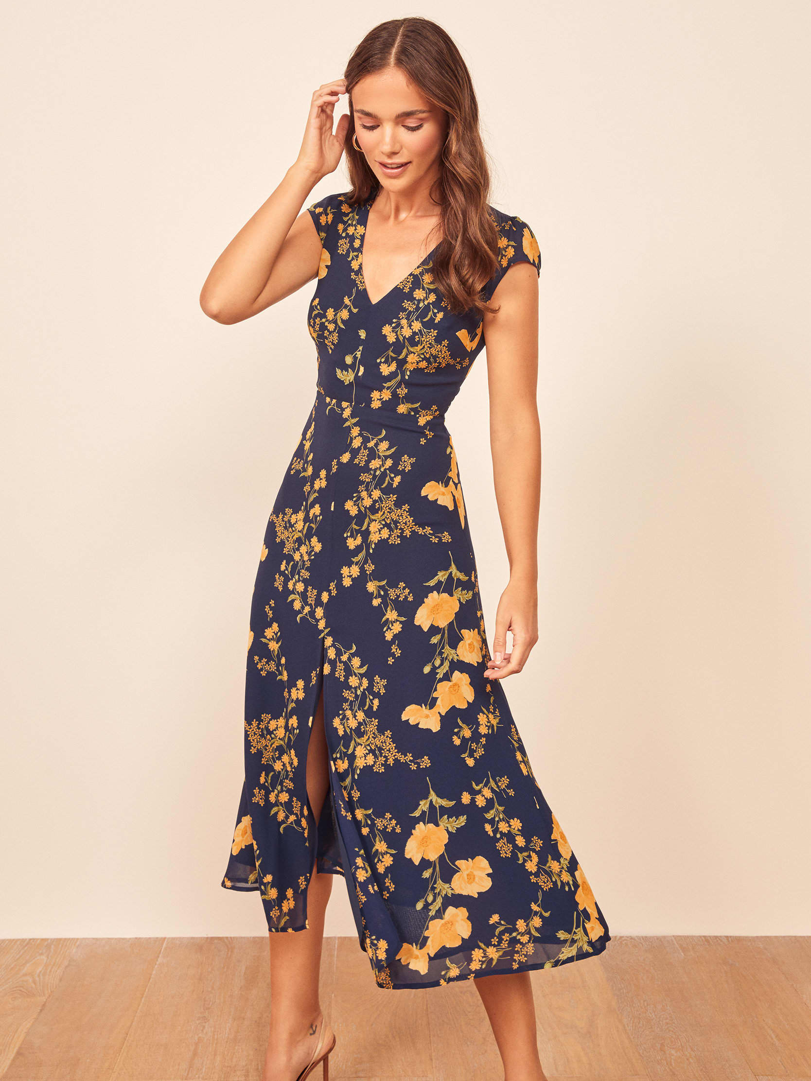 This is a midi length dress with a v neckline, a center back cutout and a center front slit.
