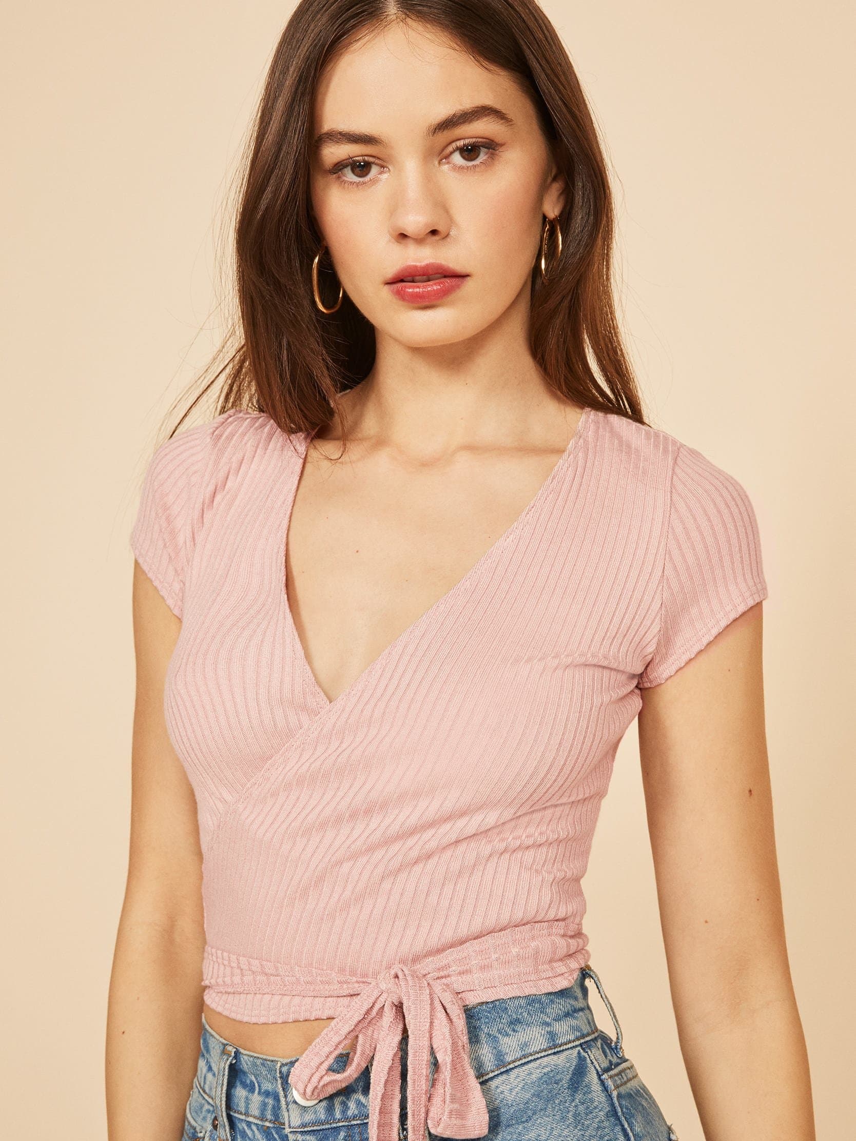 slightly cropped, wrap top with short sleeves and a v neckline.