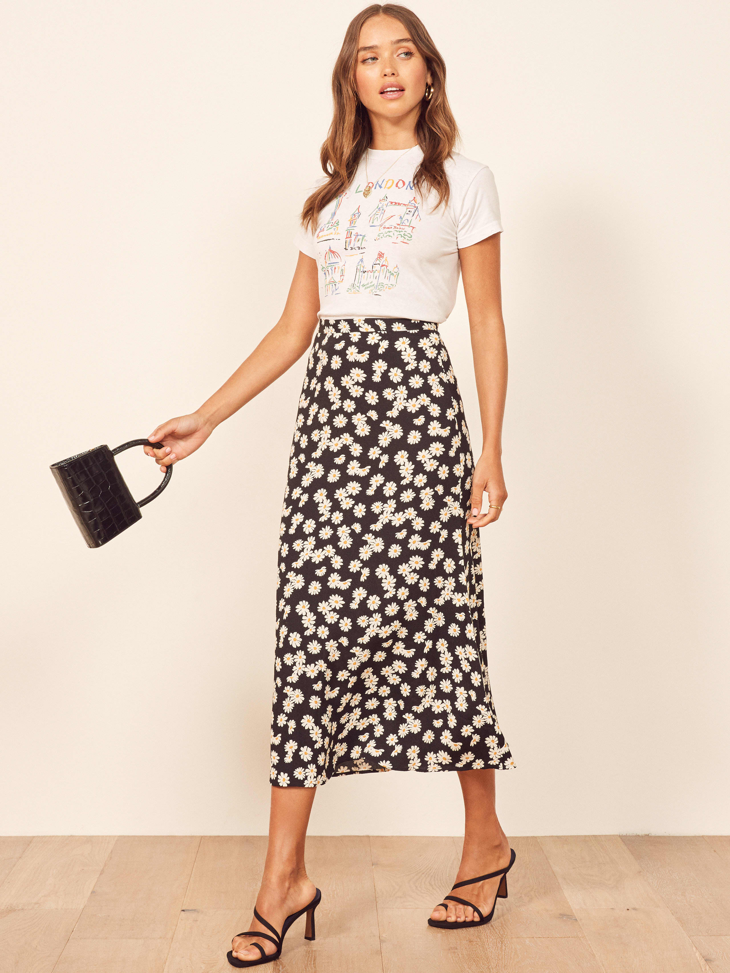 This is a high rise, midi length skirt with a slim fitting waist and center back zipper.